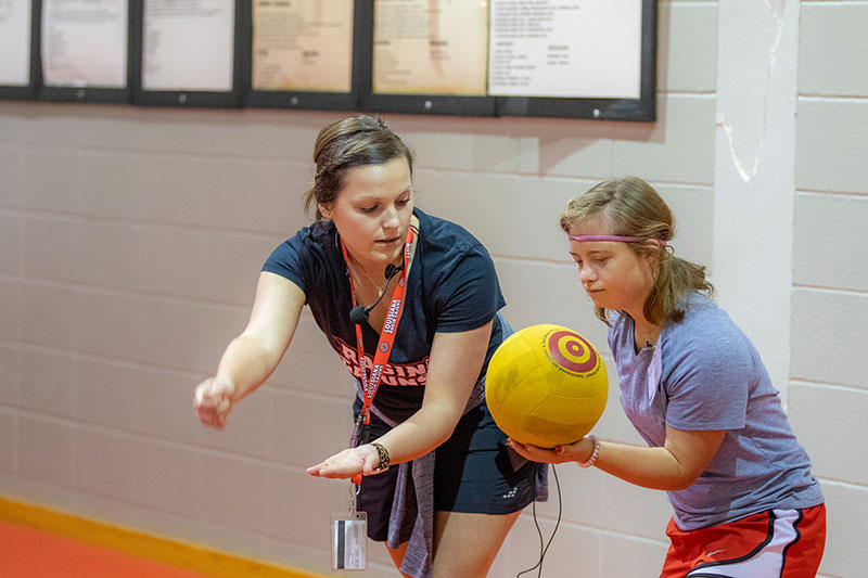 A student in the MS in Kinesiology graduate program working with a child on the University of Louisiana at Lafayette campus